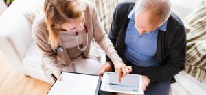 Nurse and senior discuss his care plan on a tablet